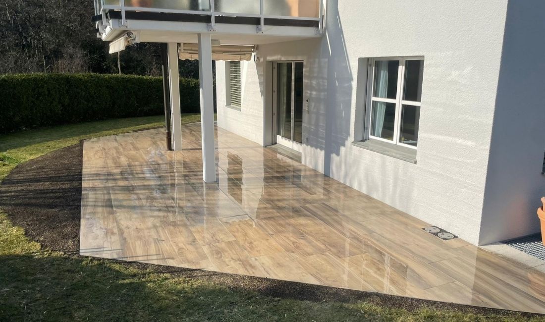 Terrasse mit Platten in Holzoptik unter einem Balkon
